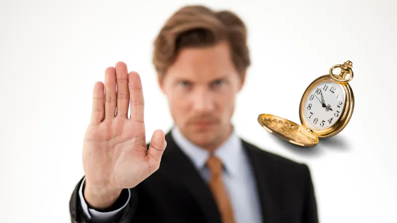 Homme montrant sa main en signe de stop d'attendre le bon moment, La montre montre le temps