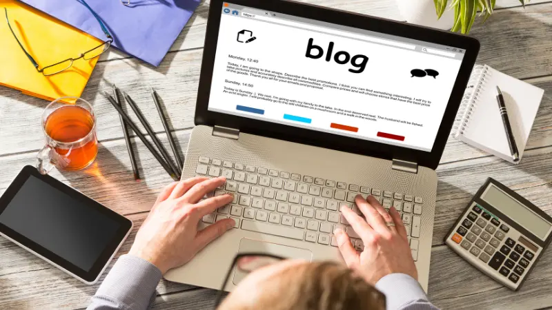 Concept de blog, les mains d'une femme entrain d'écrire un article de blog sur son écran