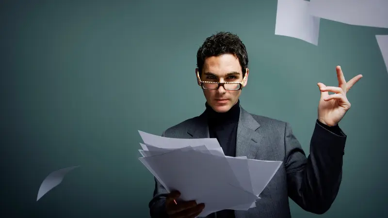 Homme d'affaire en lunette noire  entrain de jeter des feuille