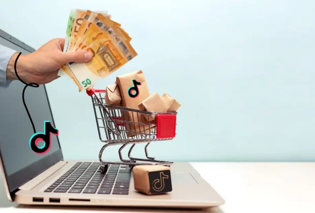 Concept de tiktok Business, une main qui sort d'un pc avec de l'argent, un chariot avec de la marchandise sur le pc (les achats)