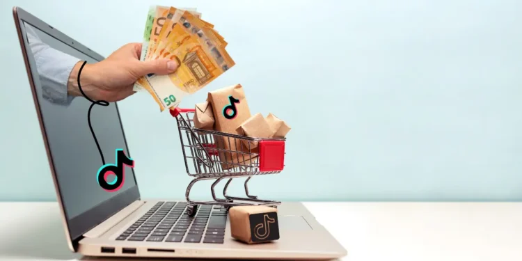 Concept de tiktok Business, une main qui sort d'un pc avec de l'argent, un chariot avec de la marchandise sur le pc (les achats)