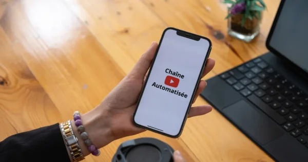 Une femme tient un smartphone et utlise l'application de vidéo YouTube