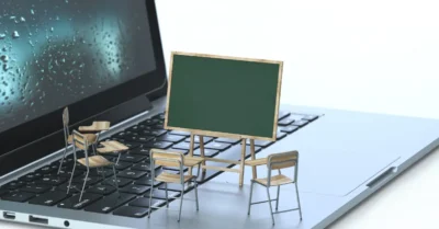 Tableau noir et chaises sur le clavier d'un ordinateur portable, rendu 3D, image conceptuelle. Concepts de formation en ligne et d'apprentissage en ligne